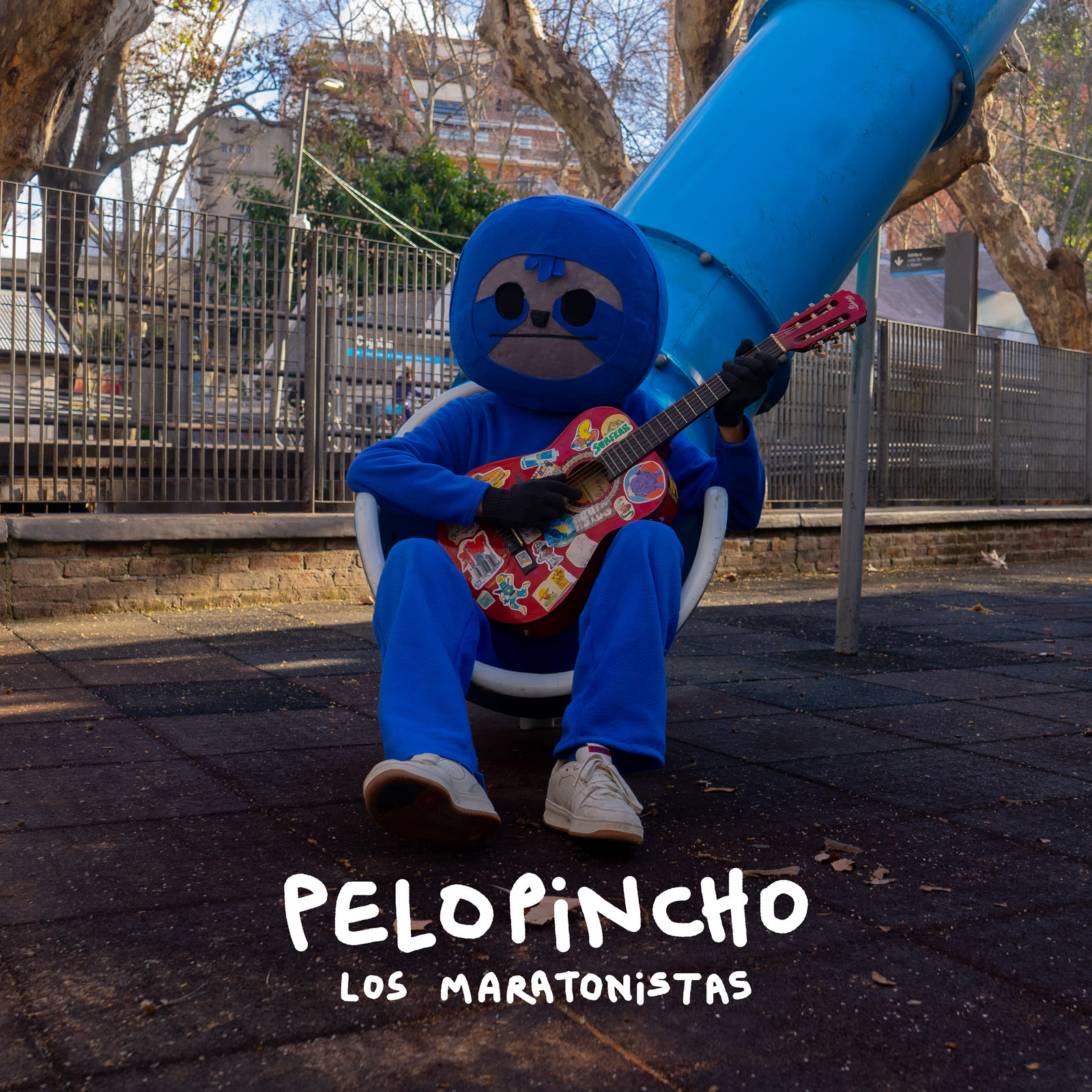 Tapa de Pelopincho: el perezoso celeste sentado en el tobogán de una plaza, tocando una guitarra roja llena de stickers.