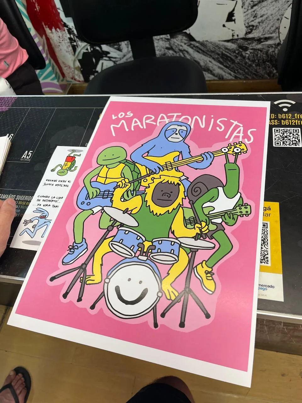 Poster rosa de Los Maratonistas con la banda de animales tocando.